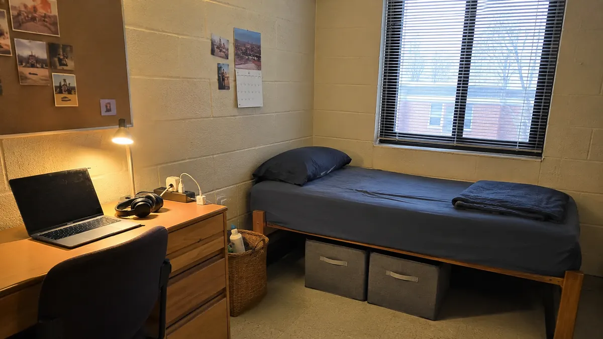 Dorm room with a bed, desk and under-bed storage